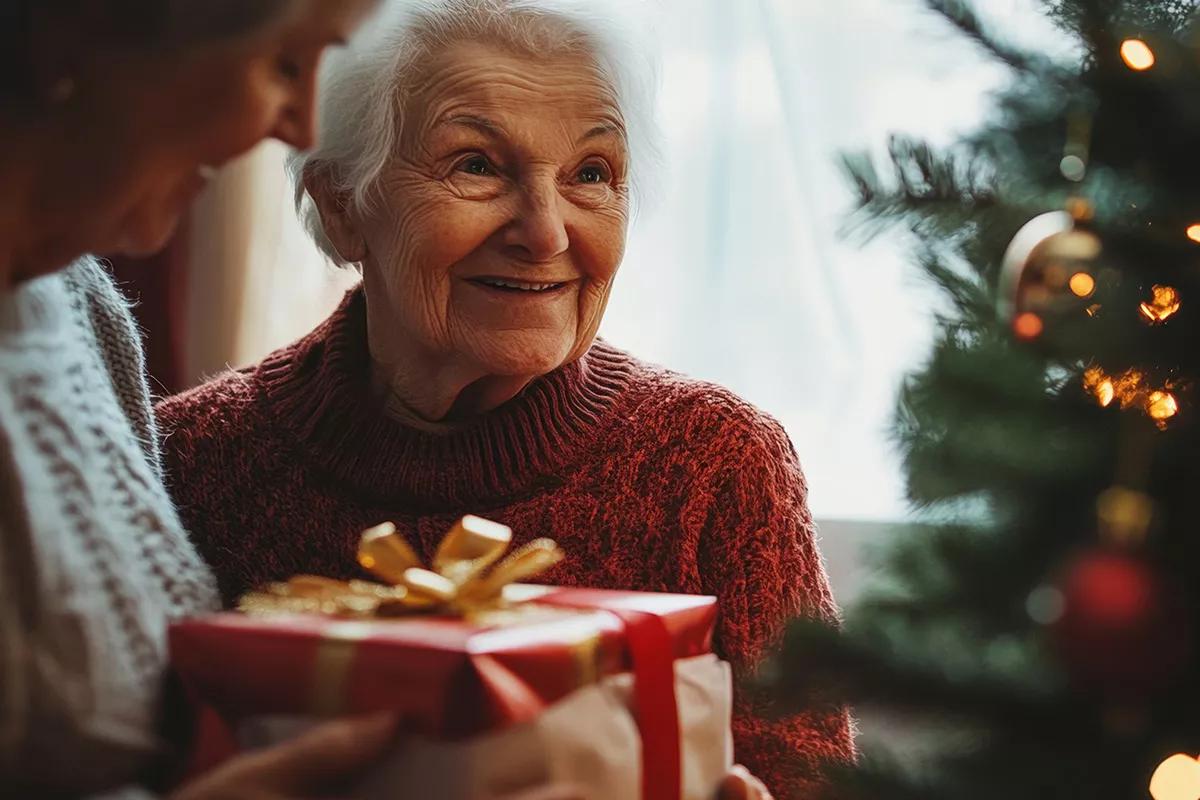 Bild einer älteren Person, die ein Weihnachtsgeschenk erhält